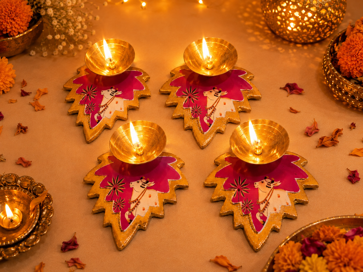 Handcrafted leaf-shaped diya with traditional cow motif lit for Diwali